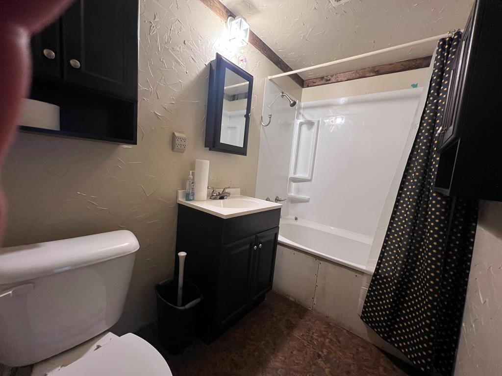 Full bathroom with toilet, vanity & shower/tub com